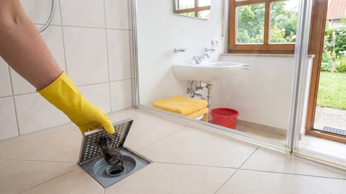 Haare werden aus dem Duschablauf entfernt – Abfluss und WC, Mühlacker